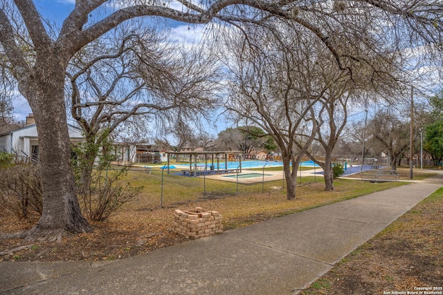 view of community with a swimming pool and a lawn