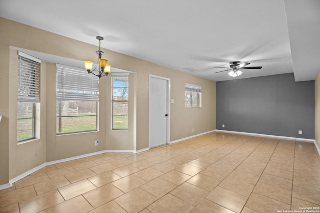 tiled empty room with ceiling fan with notable chandelier