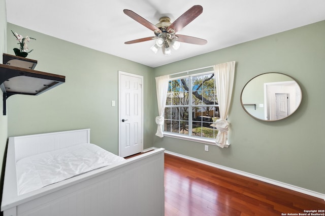 bedroom with a ceiling fan, baseboards, and wood finished floors