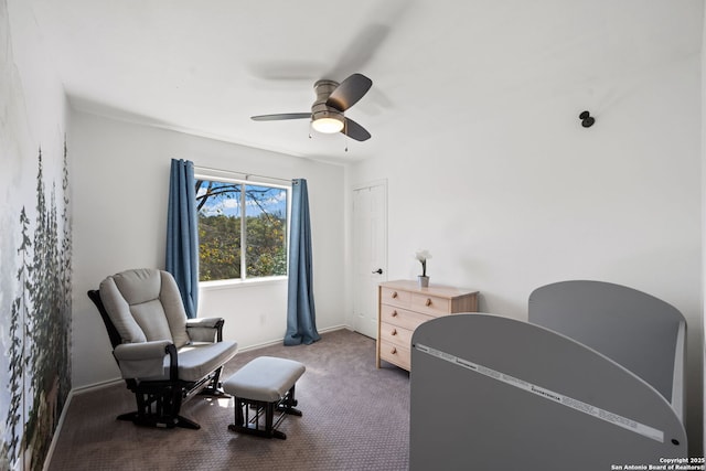 sitting room featuring carpet, baseboards, and a ceiling fan