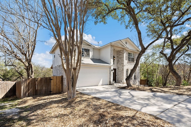 traditional home with brick siding, a gate, fence, a garage, and driveway