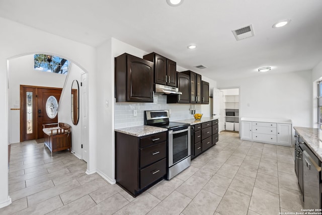 kitchen featuring under cabinet range hood, stainless steel appliances, visible vents, dark brown cabinets, and backsplash