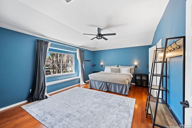 bedroom featuring ceiling fan, baseboards, and wood finished floors