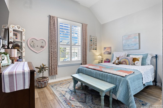 bedroom featuring wood finished floors, baseboards, and vaulted ceiling