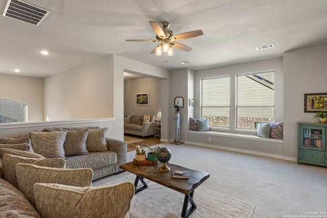 carpeted living area featuring visible vents, recessed lighting, and baseboards