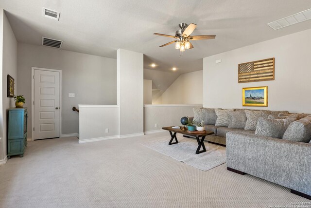 living area featuring visible vents, carpet flooring, and a ceiling fan