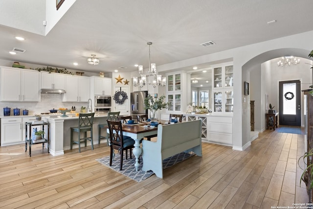 dining area featuring light wood-style flooring, recessed lighting, visible vents, and a chandelier