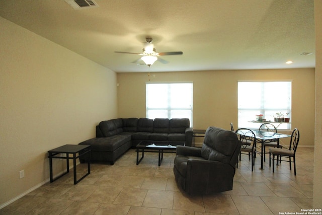 tiled living room featuring ceiling fan and plenty of natural light