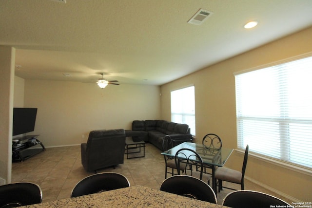 tiled living room featuring ceiling fan