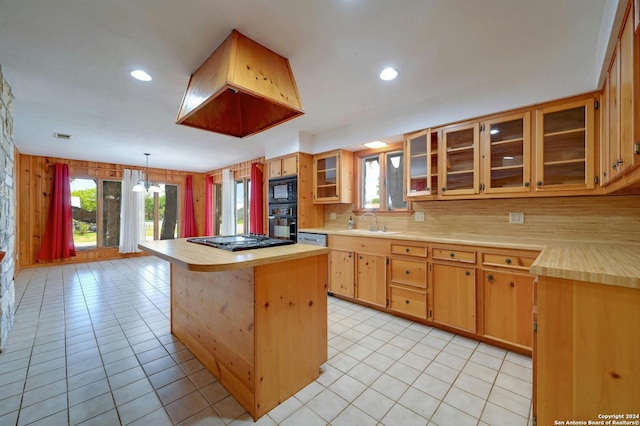 kitchen with decorative light fixtures, backsplash, a center island, light tile patterned floors, and black appliances