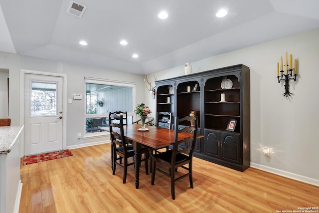 dining area featuring lofted ceiling and light hardwood / wood-style floors