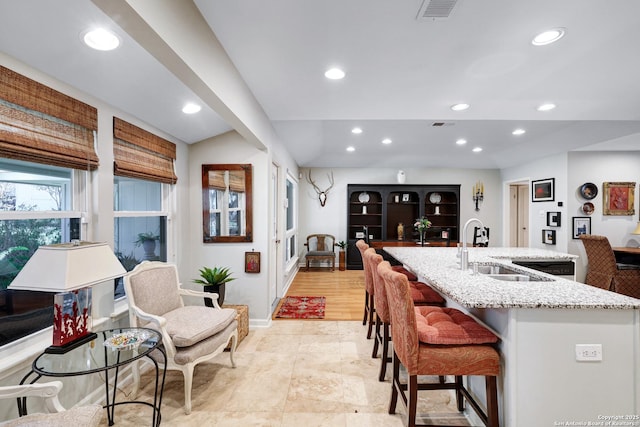 kitchen with a breakfast bar area, sink, and a center island with sink