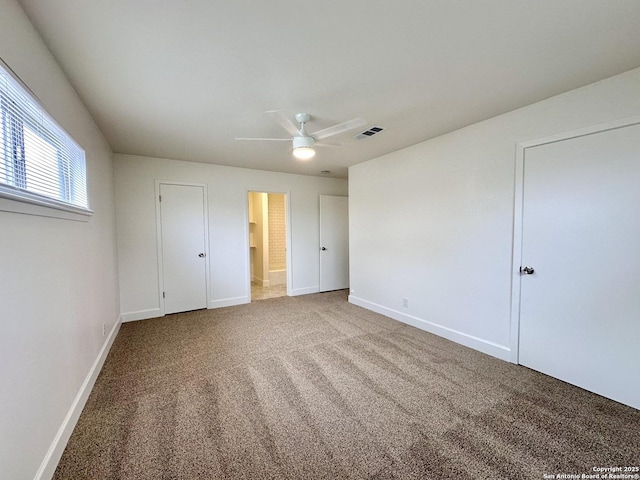 unfurnished bedroom with carpet floors, ceiling fan, and ensuite bath