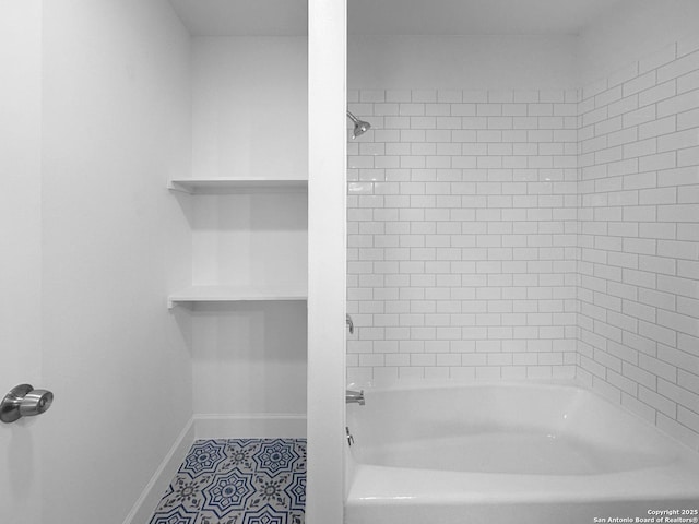 bathroom with tiled shower / bath and tile patterned flooring