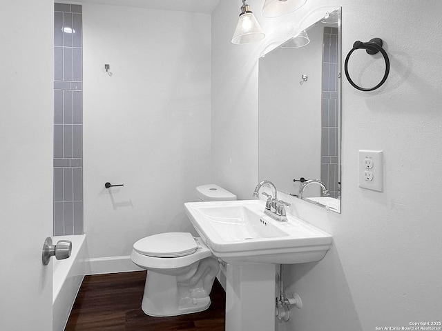 bathroom featuring hardwood / wood-style flooring, shower / bathing tub combination, and toilet