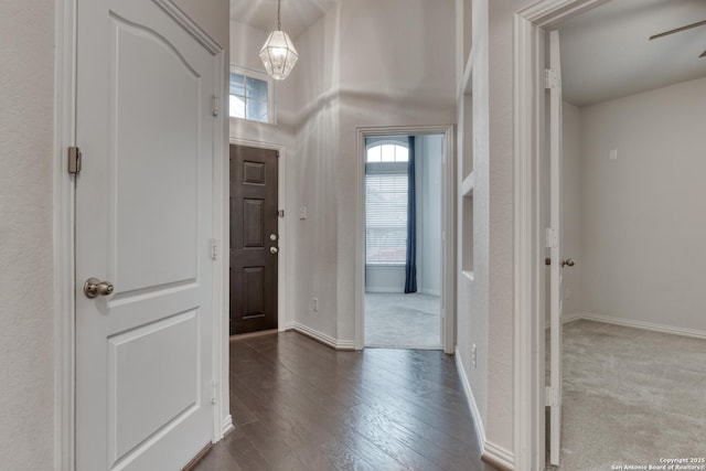 entrance foyer featuring dark wood-type flooring and an inviting chandelier