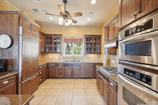 kitchen featuring appliances with stainless steel finishes, tasteful backsplash, sink, ornamental molding, and light tile patterned floors