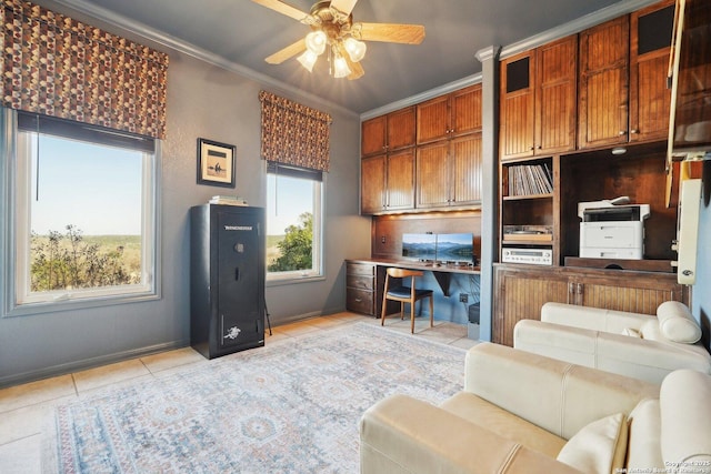 tiled office space featuring ceiling fan, ornamental molding, and built in desk