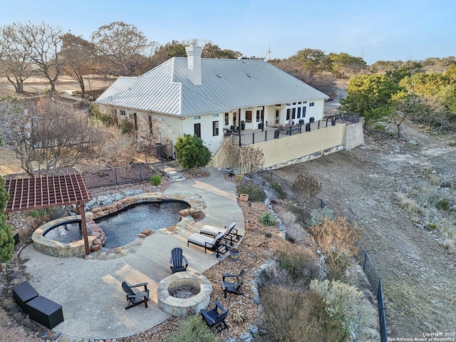 rear view of house with central AC, an outdoor fire pit, a pool with hot tub, and a patio area