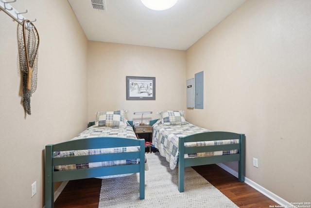 bedroom with hardwood / wood-style flooring and electric panel