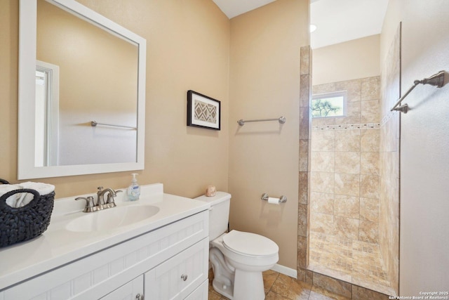 bathroom featuring vanity, tiled shower, and toilet