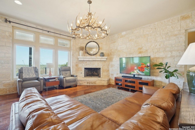 living room with a fireplace, dark hardwood / wood-style flooring, and a notable chandelier