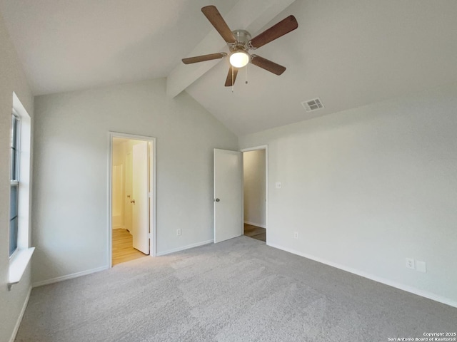 unfurnished bedroom featuring lofted ceiling with beams, ensuite bathroom, light carpet, and ceiling fan