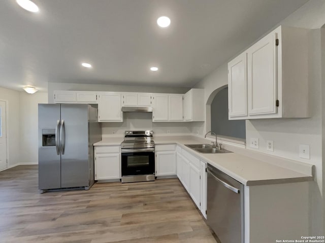 kitchen featuring sink, stainless steel appliances, white cabinets, and light wood-type flooring