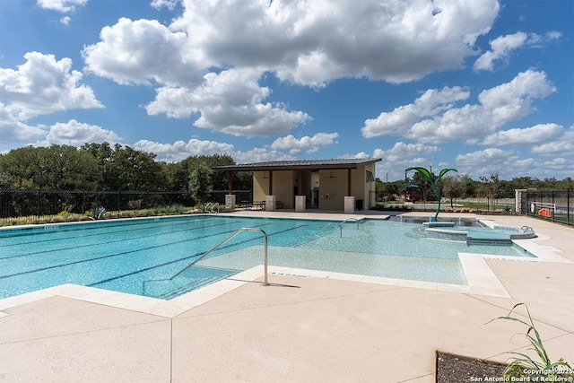 view of swimming pool featuring a hot tub and a patio