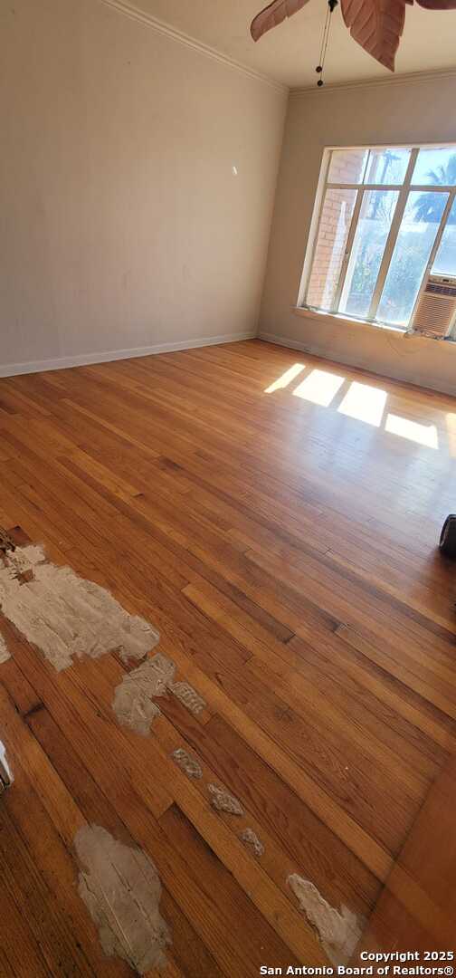 spare room with crown molding, hardwood / wood-style flooring, and ceiling fan