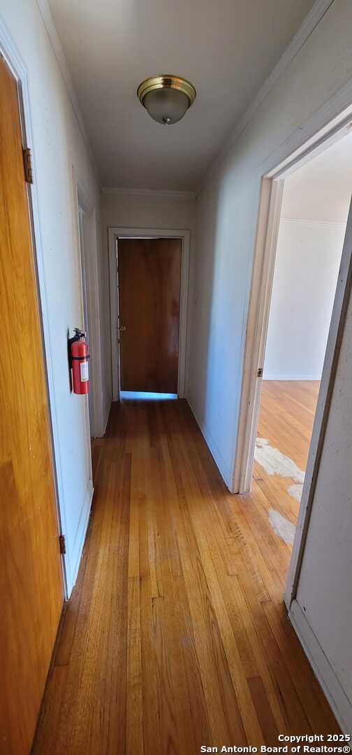 corridor featuring light hardwood / wood-style flooring and ornamental molding