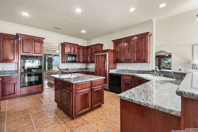 kitchen with sink, kitchen peninsula, light stone countertops, a kitchen island with sink, and black appliances