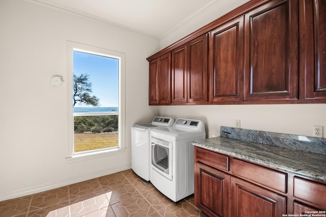 washroom featuring cabinets, ornamental molding, and washing machine and clothes dryer