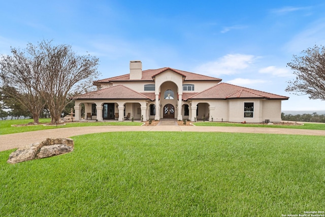 mediterranean / spanish house with a front lawn