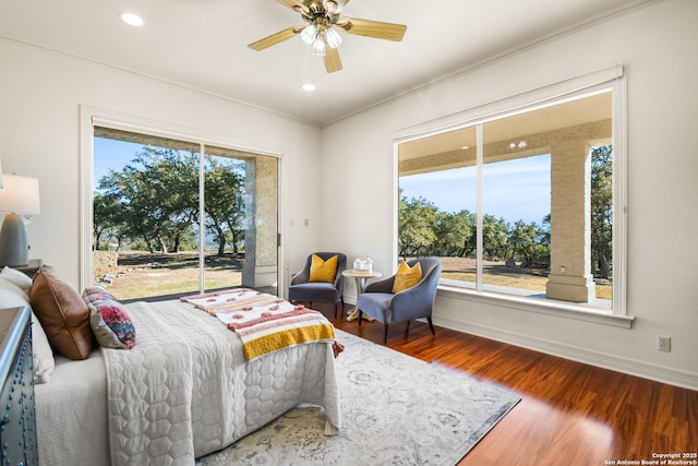 bedroom with crown molding, hardwood / wood-style floors, multiple windows, and access to outside