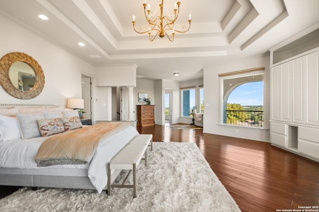 bedroom with decorative columns, dark hardwood / wood-style floors, an inviting chandelier, and a tray ceiling