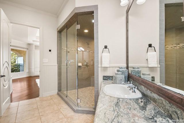 bathroom with walk in shower, tile patterned floors, crown molding, and vanity