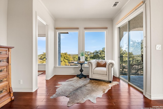 living area featuring ornamental molding and dark hardwood / wood-style flooring