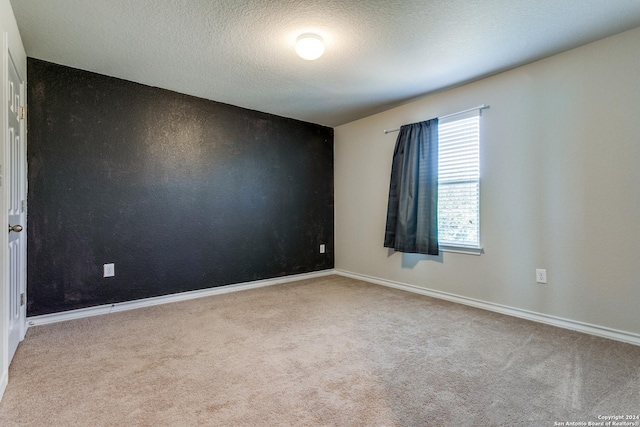 carpeted spare room featuring a textured ceiling