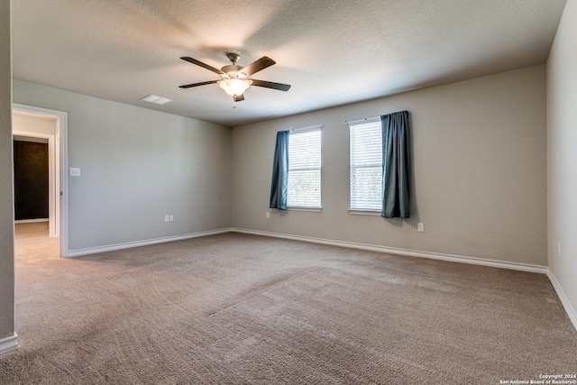 spare room with light carpet, a textured ceiling, and ceiling fan