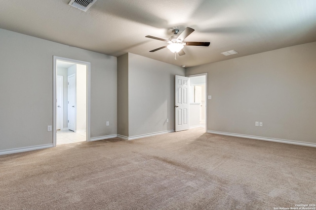 empty room featuring ceiling fan and light colored carpet