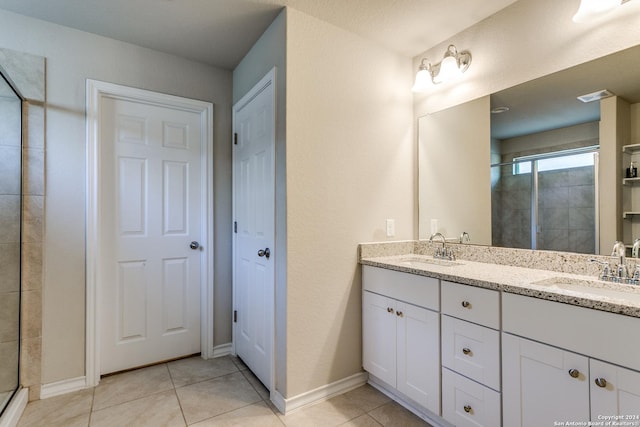 bathroom featuring tile patterned flooring, vanity, and walk in shower