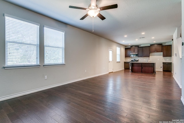 unfurnished living room featuring dark hardwood / wood-style flooring, sink, a textured ceiling, and ceiling fan