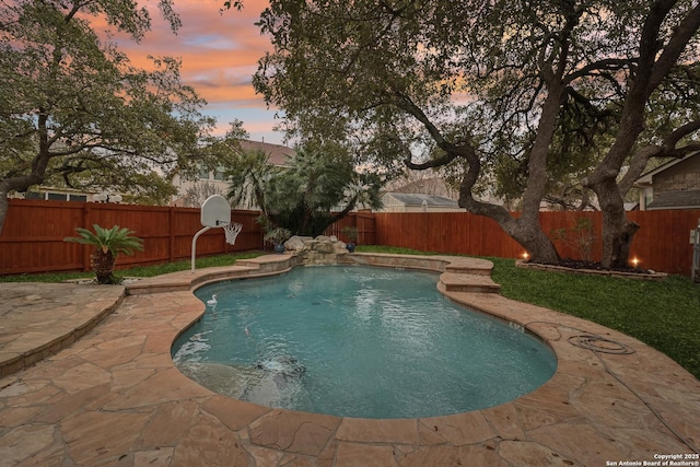 pool at dusk featuring a patio area