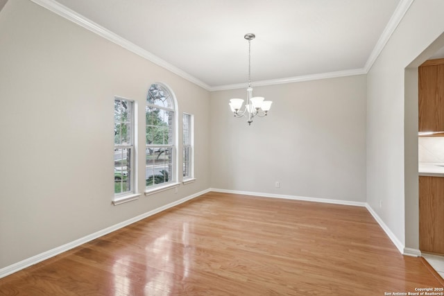 unfurnished room featuring ornamental molding, a notable chandelier, and light wood-type flooring