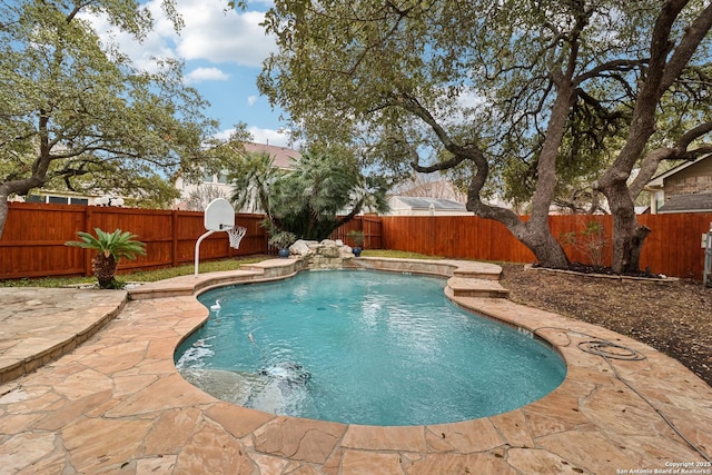 view of swimming pool featuring pool water feature and a patio