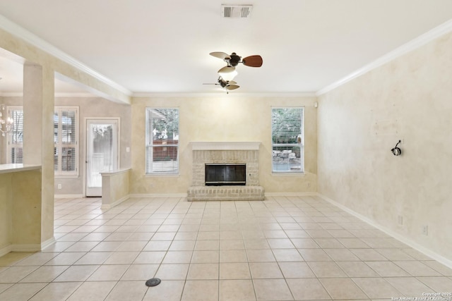 unfurnished living room with light tile patterned flooring, ornamental molding, ceiling fan with notable chandelier, and a fireplace