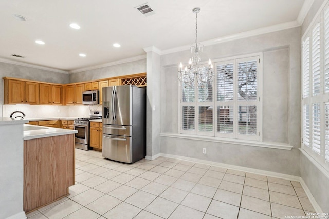 kitchen featuring pendant lighting, light tile patterned floors, ornamental molding, and appliances with stainless steel finishes