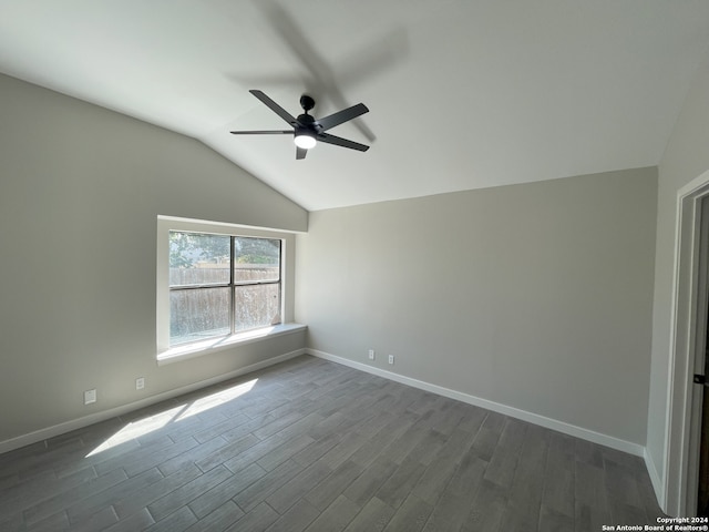 unfurnished room with vaulted ceiling, dark hardwood / wood-style floors, and ceiling fan