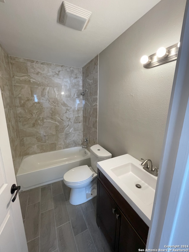 full bathroom featuring vanity, toilet, and tiled shower / bath